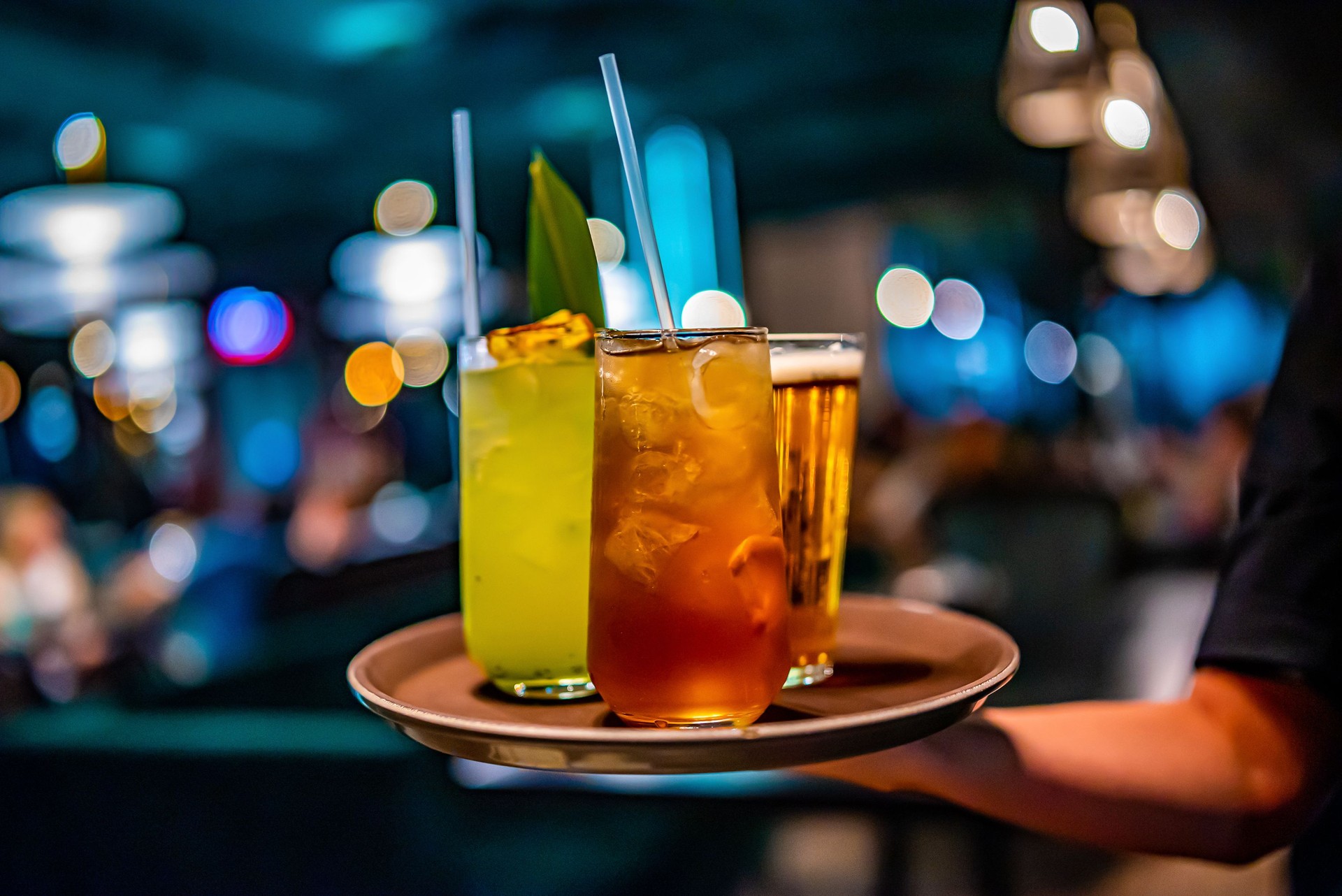 glasses alcohol cocktail set and beer on a waiter tray in bar